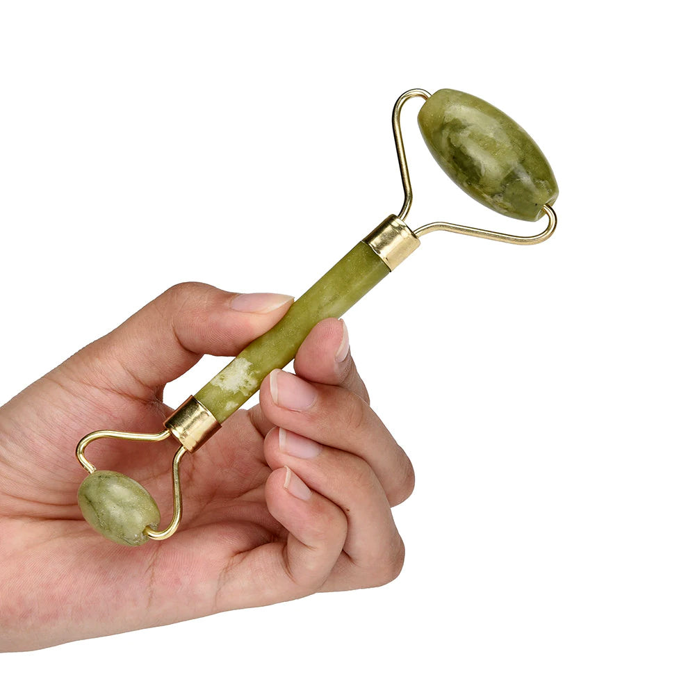 Close-up of a woman scraping her jawline with a green jade gua sha tool for facial lifting and contouring.