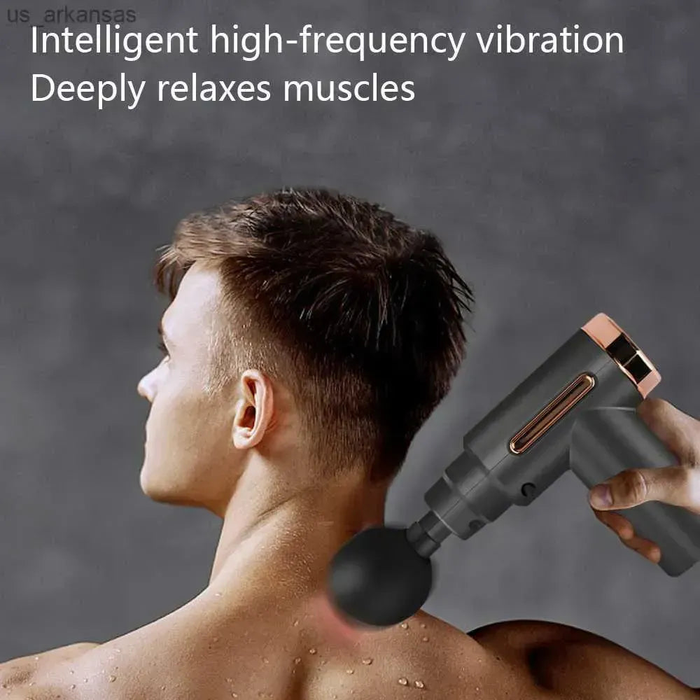 Close-up of an athlete using a black portable mini massage gun on their quad muscles for post-workout recovery.