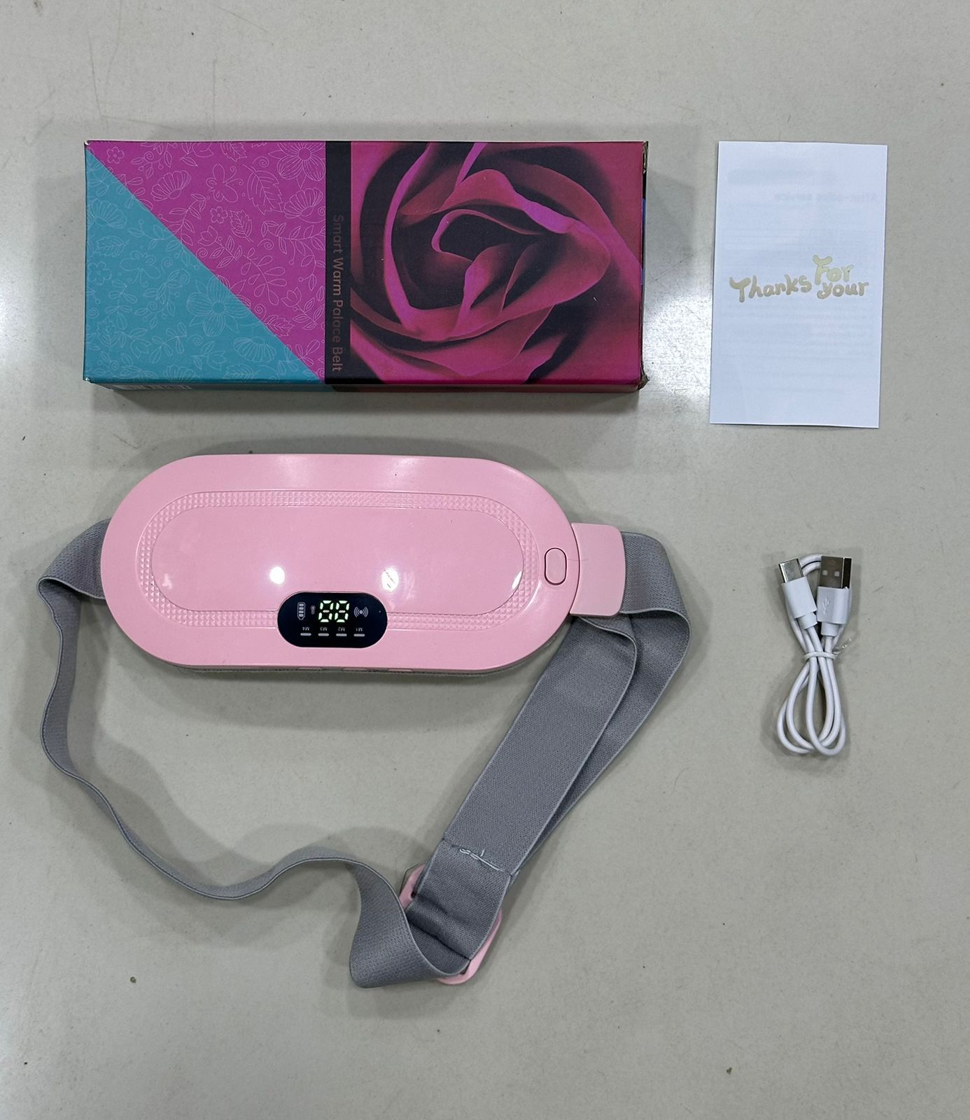 Close-up of a woman wearing a pink cordless menstrual heating pad belt around her waist for lower back and period cramp relief.