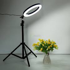 A lifestyle shot of a content creator filming a makeup tutorial using a 12-inch LED ring light with an iPhone mounted in the center holder.